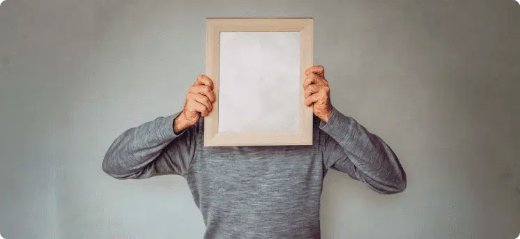 Hombre con cuadro tapando su rostro en referencia a la validación del buyer persona con ayuda de un mapa de empatía