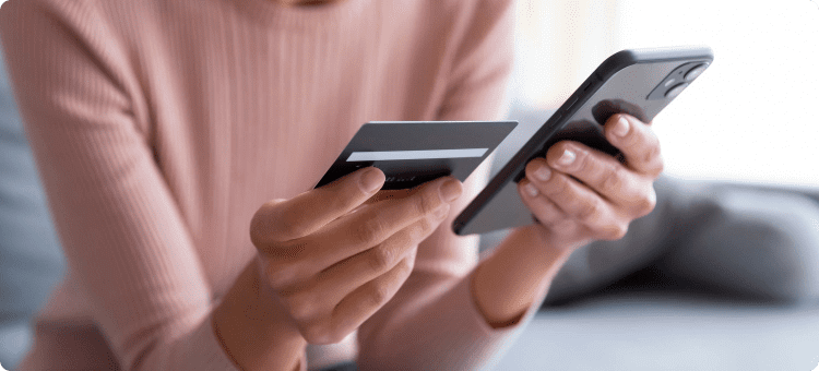 Mujer ingresando los datos de su tarjeta de crédito en su celular en referencia a las campañas de marketing de temporada