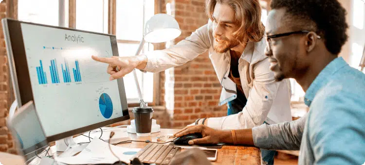 Dos personas viendo informes de resultados en referencia a que están decidiendo si necesitan la automatización de negocios o no