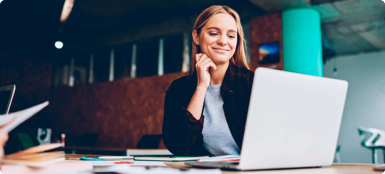 Mujer sonriendo frente a su pantalla de computador en referencia a las recomendaciones para una landing page efectiva